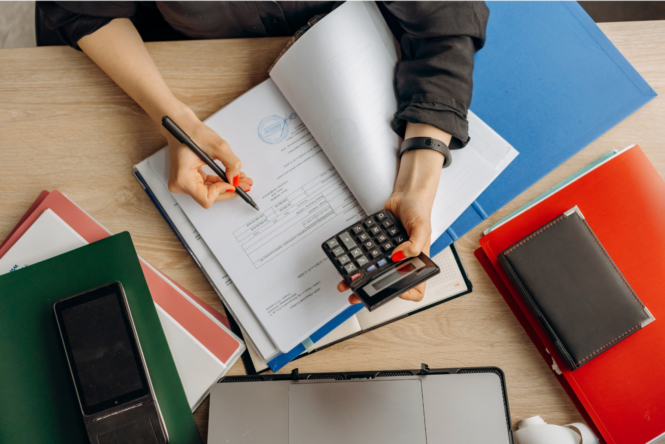 Accountant reviewing financial statements and using a calculator