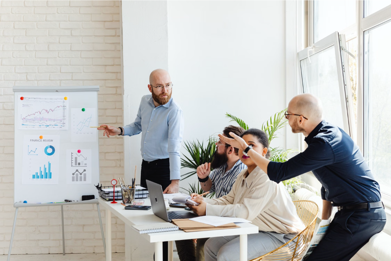 Consultant presenting SAP financial reporting data on a whiteboard to the project team